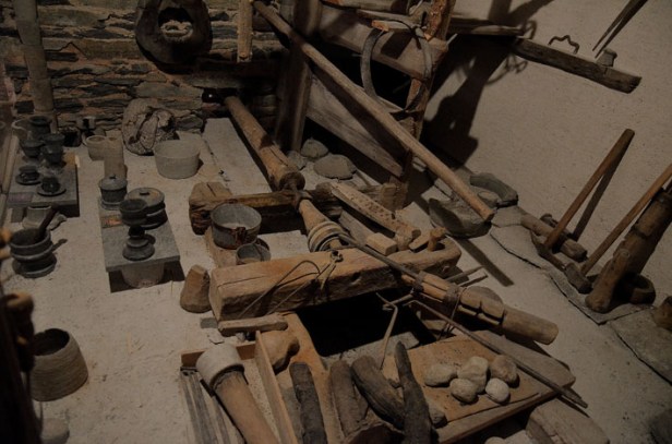 Reconstructed workshop of traditional manufacture of soapstone cooking pots at the Museum Ciäsa Granda in Stampa (Bergell). The pots were made by turning them on a lathe, which was driven by water power. This technique was so well adapted that it hardly changed after having been introduced in the Roman period. Flanking the central lathe are numerous objects also made from soapstone, such as drinking glasses. Photo: Per Storemyr