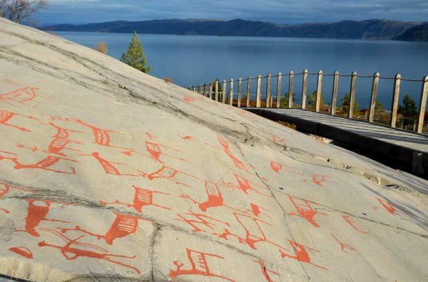 Reindeer hunter with bow and arrow (low, left) in the prehistoric Alta rock art. Photo: Per Storemyr