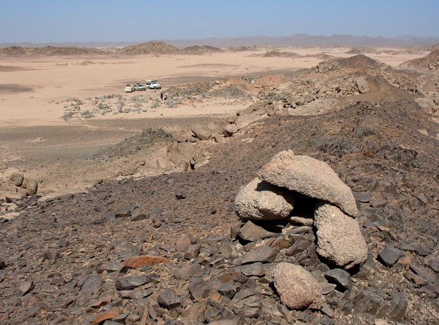 Volcanic dyke at Rod el-Gamra showing signs of exploitation by Palaeolithic man. The naoi quarry is in the background. Photo: Per Storemyr
