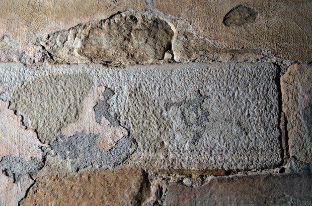 Overflatebearbeiding av finbåndet, lys marmorkvader innvendig i korets østgavl. Merk "slaget" på oversiden og den "fingropete" overflaten. På bildet kan man også se detaljer i gavlen puss, med en tynnpuss under (grålig) og slemming over, der sporene etter kalkkosten er godt synlige. Foto: Per Storemyr