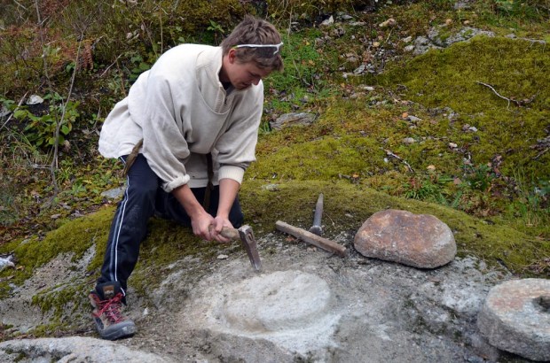 Roy Harald Brendsdal hogger dreiekvern etter vikingtidens mønster i Hyllestad. Foto: Per Storemyr