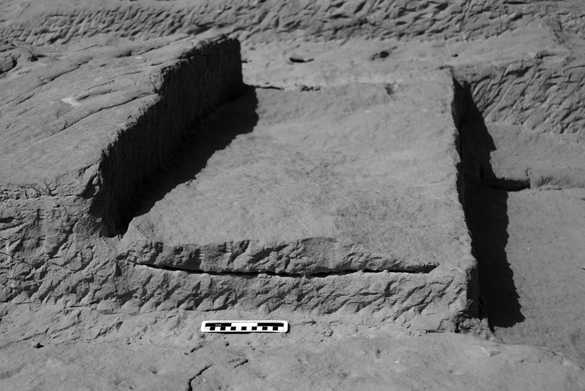 Chisel holes left in a failed attempted to induce a fracture along the base of a block in the Middle Kingdom Wadi Shatt el-Rigal sandstone quarry near Gebel el-Silsila. Note the rough upper surface where the block broke free of the bedrock above the line of chisel holes. Smallest scale division is 1 cm. Photo by JAMES HARRELL.