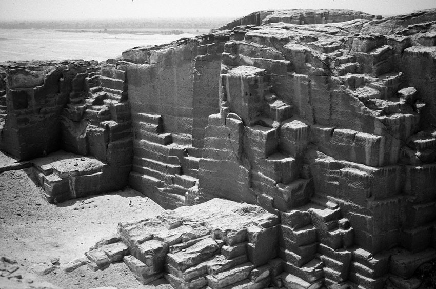 Multiple-block extraction on descending platforms in the New Kingdom to Late Period part of the el-Sawayta limestone quarry near Samalut. Note the wide, shallow steps left by offset platforms and, at center and at left, the two narrower but deeper, squarish platform remnants. Photo by JAMES HARRELL.