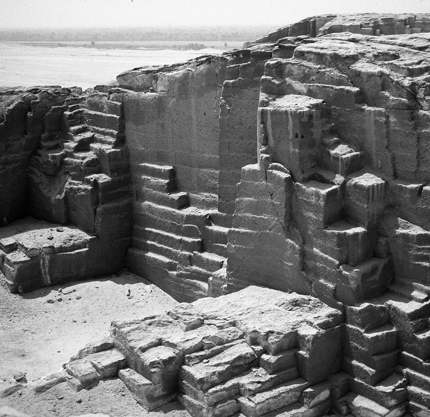 Multiple-block extraction on descending platforms in the New Kingdom to Late Period part of the el-Sawayta limestone quarry near Samalut. Note the wide, shallow steps left by offset platforms and, at center and at left, the two narrower but deeper, squarish platform remnants. Photo by JAMES HARRELL.