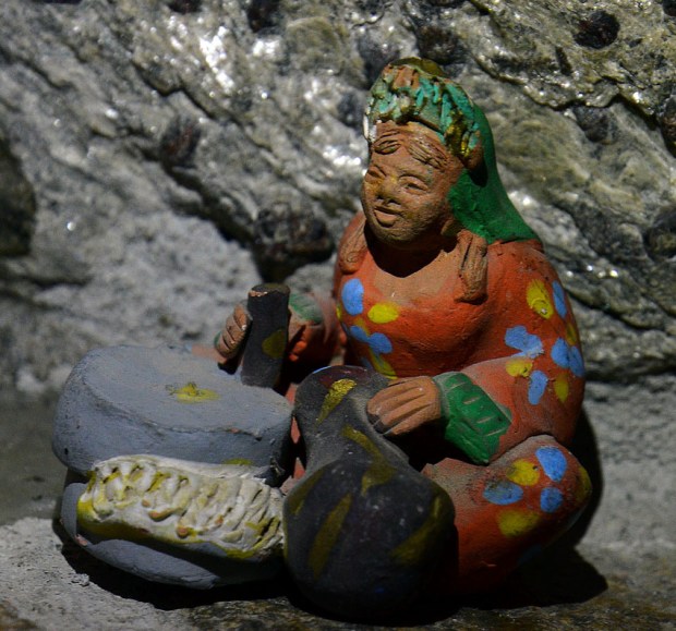 Woman grinding grain with a rotary hand quern. Modern clay model, Aswan, Egypt. Photo by Per Storemyr