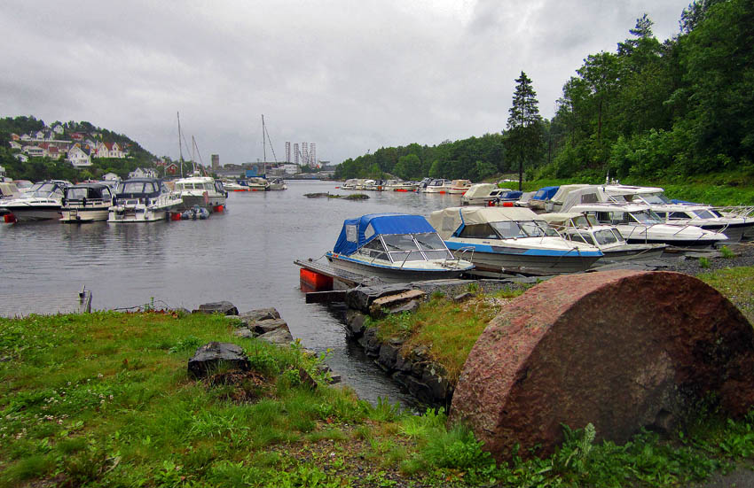 Møllebukta i Neskilen. I forgrunnen en del av kverna til den gamle feltspatmølla som var i drift her mellom 1898 og 1928. Foto: Per Storemyr