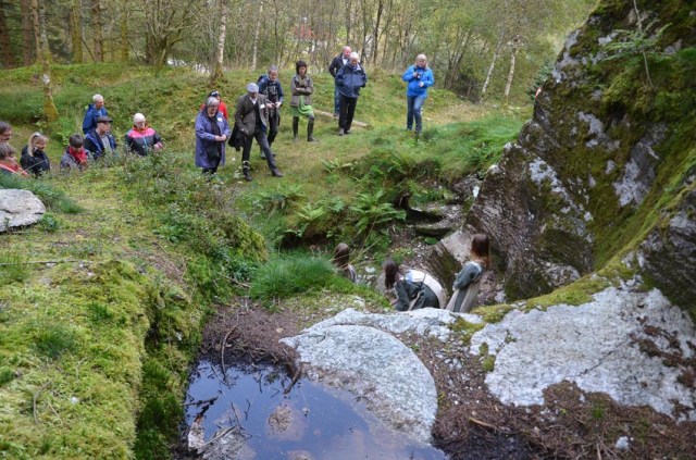 "Dronninggruva" i kvernsteinslandskapet i Hyllestad, Ytre Sogn. Her er ICOMOS på besøk i nominasjonsprosessen mot verdensarvsted i 2014; man blir vist rundt av godt trente unge guider fra Hyllestad skule. Men verdensarv-prosessen er nå på vent og veien videre høyst uklar. Foto: Per Storemyr