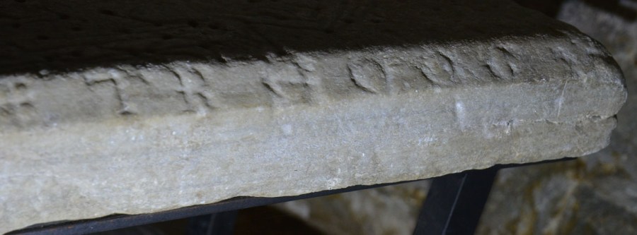 Detalj av gravplaten fra 1200-tallet som nå befinner seg i søndre sidealternisje i Værnes kirke. Gravplaten er hogd i hvit marmor med karakteristiske «bånd» av mørkere mineraler. Platen kommer etter all sannsynlighet fra Nidarosdomens gamle brudd i Sparbu. Foto: Per Storemyr.