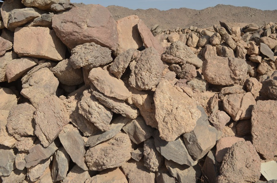 Studying the walls of the fortified settlement at site 9 in Wadi el-Hudi can give an idea of where the stones came from: The darker stones are from “granitic” veins, the lighter one from very weathered, course granite in the mine itself. Photo by Per Storemyr.