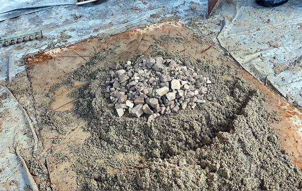 Hotmix fra Hyllestadkalk: Nedknust brentkalk legges i en grop av mursand, mer sand legges over kalken, litt vann helles over – og dermed blir kalken lesket. Foto: Per Storemyr