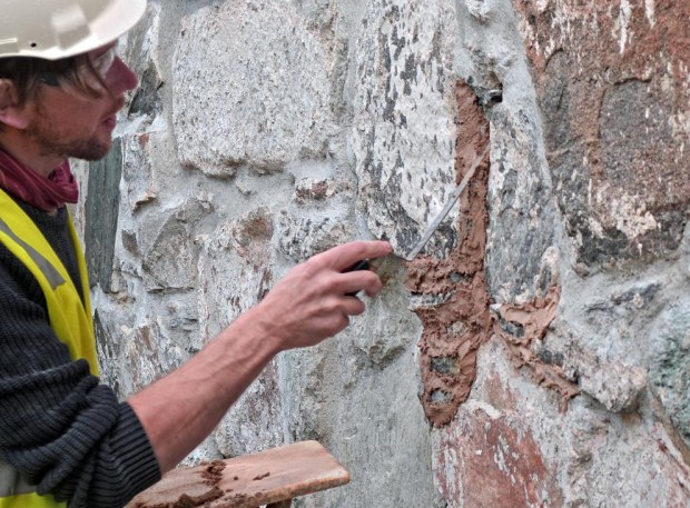 George Murphy er spesialist på restaureringsmuring. Her tester han mørtel laget fra nybrent Hyllestadkalk på Stavanger domkirke i oktober 2017. Foto: Per Storemyr