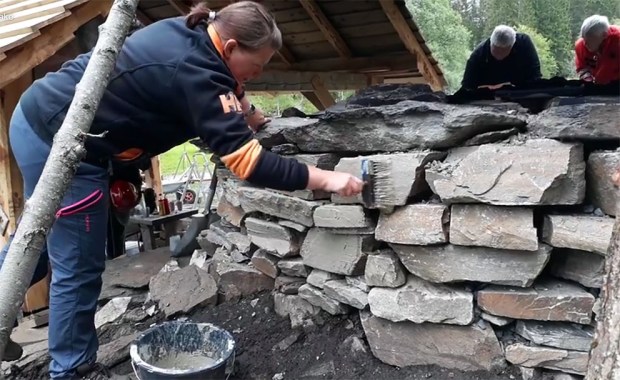 Frøydis Akse tester en enkel slemming laget av nybrent, lesket kalk på nordsiden av kalkovnen i juni 2017. Foto: Per Storemyr