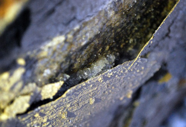 At night: A lens of ice (middle), now thawing, has broken a layer of limewash on stone. Lime kiln at Hyllestad, Western Norway. Width of image c. 5 cm. Photo by Per Storemyr