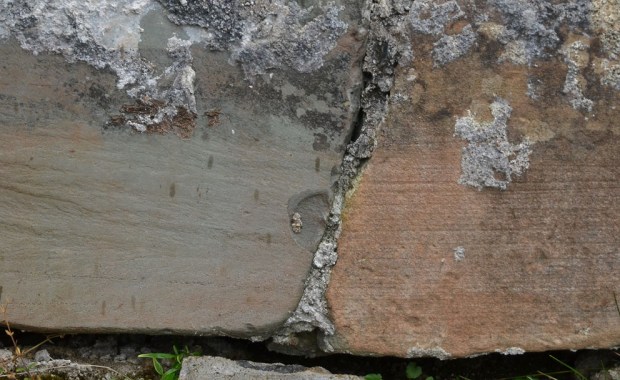 Devonsandsteinen på Kinn kirke. Til høyre: "Rustet", naturlig overflate med isskuringsstriper. Til venstre: Splittet overflate med "frisk", grønnlig farge. Foto: Per Storemyr