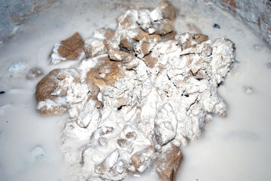 Lesking av kalken. Vi ser at den er hvit under et ytre, brulig sjikt (som kanskje kommer fra tjærestoffer i veden? og fra litt oksidert jernsulfid i steinen?). Foto: Per Storemyr