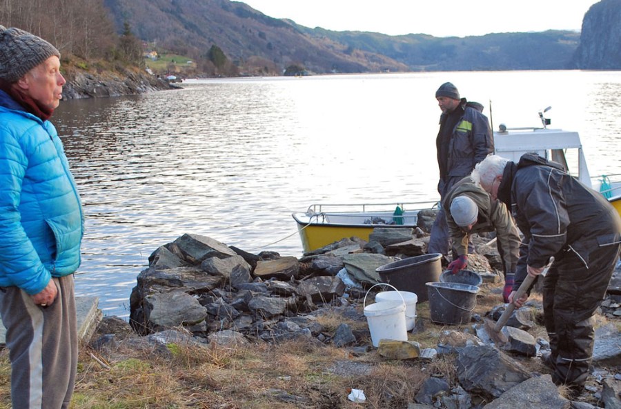 Sveinung, Oddvin og Torbjørn hogger opp marmor på kaia i Smilla, Jostein, som bor på Smilla, følger med. Foto: Per Storemyr