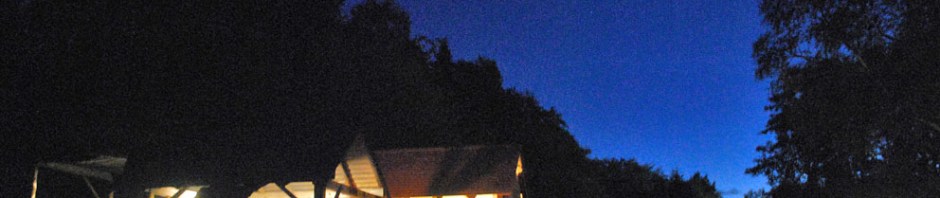 Kalkovnsmiljøet i Hyllestad. Vesleovnen er under brenning på morgenkvisten. Storovnen helt til venstre. Bak er det vedskjul og redskapsbod. Mye er bygd på dugnad og med støtte fra Riksantikvaren. Vei er viktig for levering av marmor og ved til brenning. Opphogging av marmor foregår manuelt med slegger på plassen foran de overbygde ovnene