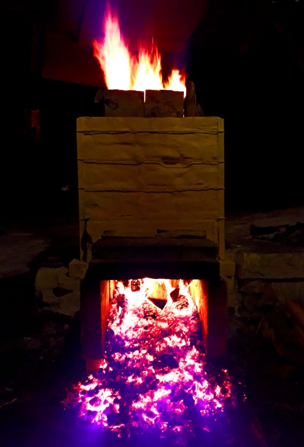 Heftig brenning med glohaugen dels utenfor fyrkammeret for å bedre på trekken