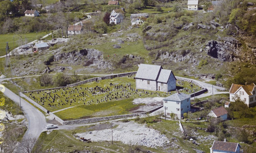 Moster gamle kirke midt i en serie av gamle steinbrudd. På bildet kan en telle 5-6 gamle brudd. Foto: Widerøes Flyveselskap, 1962 (nb.no)