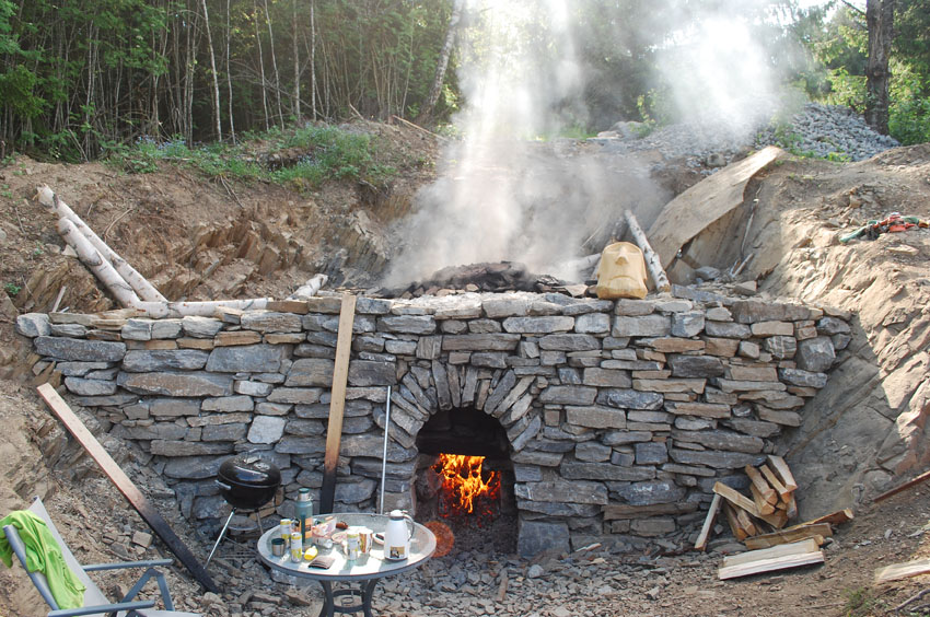 Figur 11: Kalkovnsanlegget til Tore Granmo på Helgøya, bygd i 2021. Den sylindriske ovnen har en kapasitet på ca. 10 tonn kalkstein og er bygd inn i et utsprengt søkk. Foto: Per Storemyr