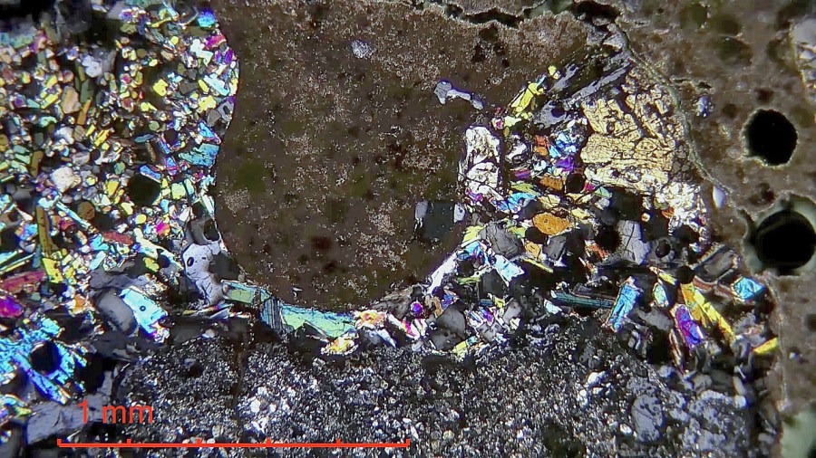 Hedrum kirke. Slagg fra kalkbrenning i hard middelaldermørtel på skipet. De typiske komponentene i slagget er pyroksen (fargerik) og melilitt (grålig). Hydraulisk bindemiddel er mørkt brunt. Krysspolarisert lys. Foto: Per Storemyr