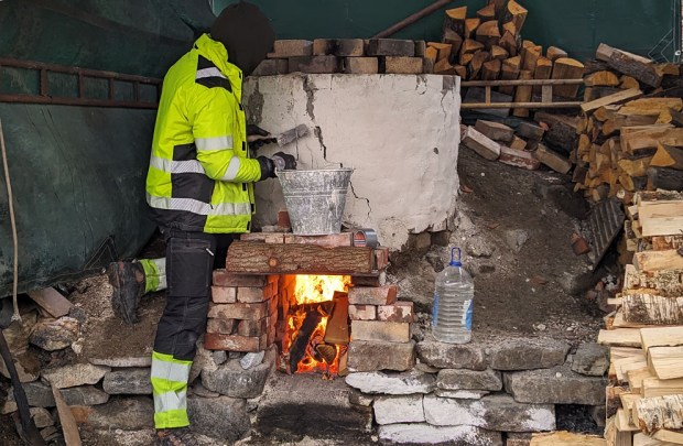 Store sprekker tettes med kalkmørtel mens oven er i drift