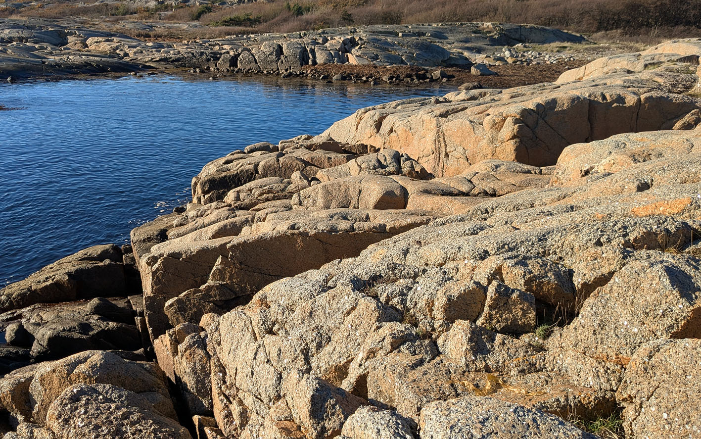 Grusforvitring i larvikitt på Rakke. Det er det nærmeste berget på bildet som har fått overflaten pulverisert. Foto: PS